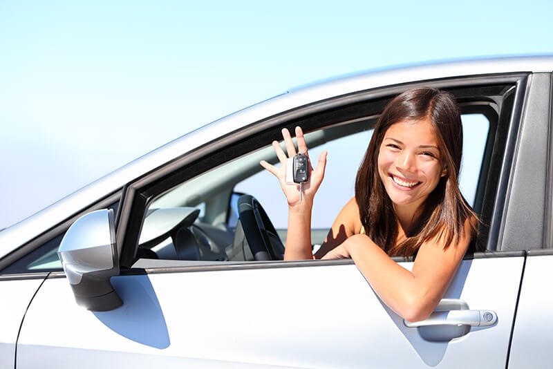 mulher mostrando chave do carro novo